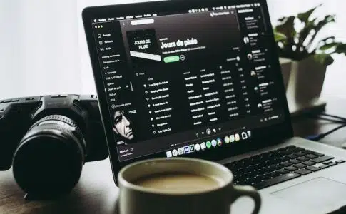 black and silver laptop computer beside white ceramic mug